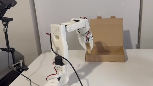 SO-101 arm carrying an eraser over a box